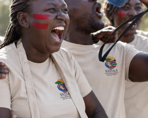 SSDAA supporters cheering while wearing SSDAA branded t-shirts, representing diaspora mobilization