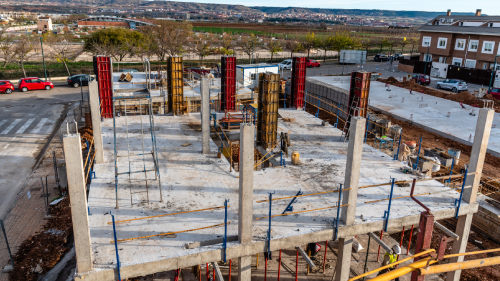 Aerial view of a building under construction, representing community development